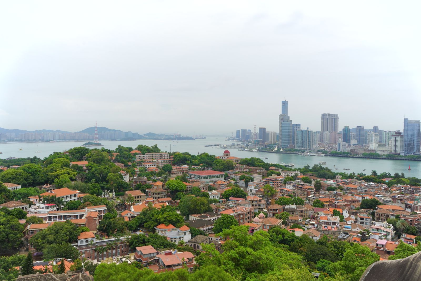 Aerial view of Gulangyu Island with the Xiamen city skyline behind it